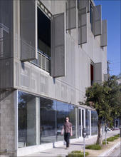 A detail view of the retail space and facade system are seen in this photo, including a planted median with an underground stormwater retention system. - Photo Credit: John Linden