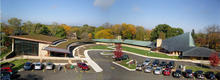 This photo shows a panoramic aerial view of the original Meeting House and new addition. Parking was considered part of the "historic fabric" of the original design. - Photo Credit: The Kubala Washatko Architects, Inc.